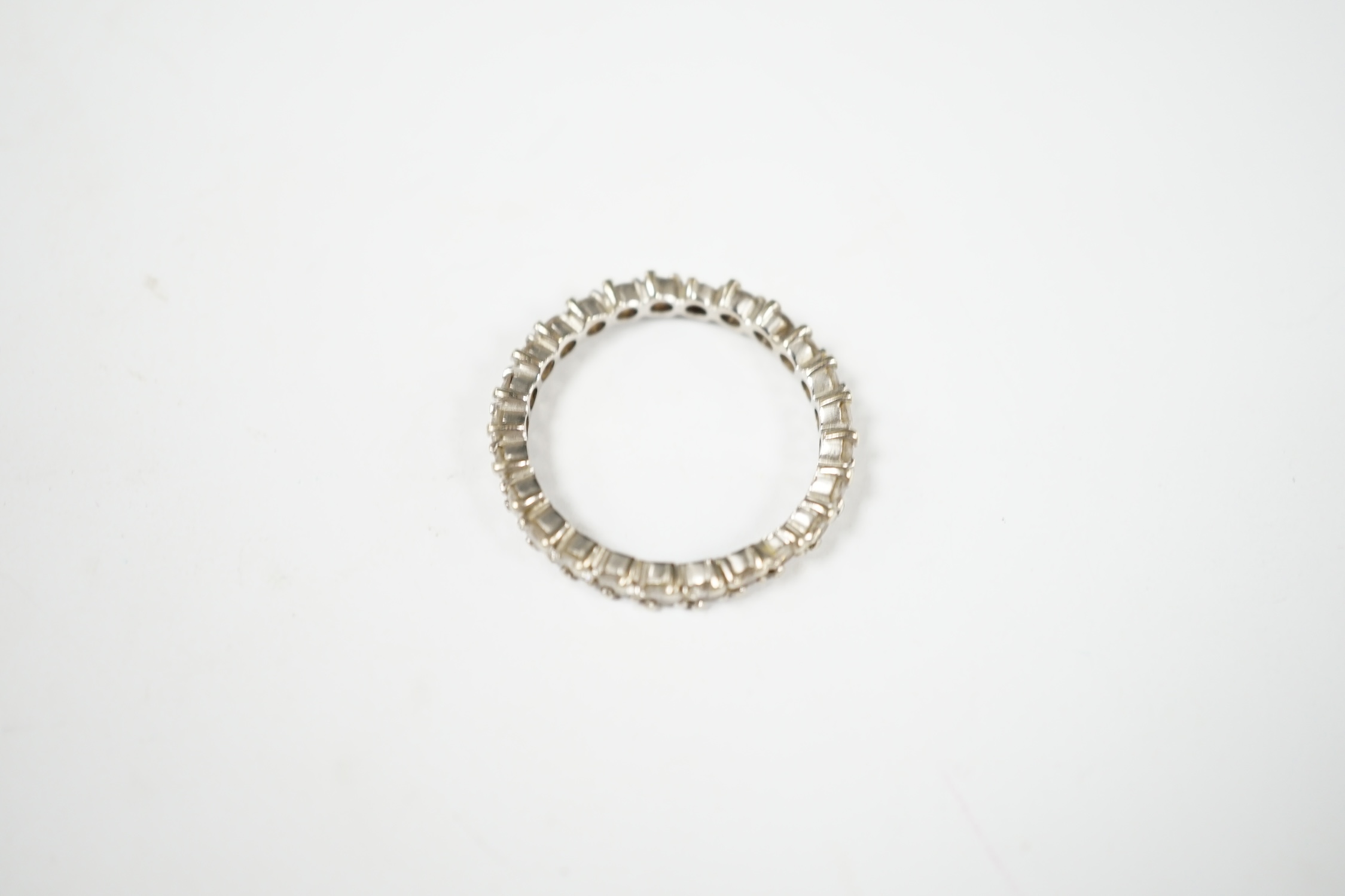 An early 20th century French 18k white gold and diamond set full eternity ring, size Q, gross weight 2.9 grams (stone missing). Condition - poor to fair
